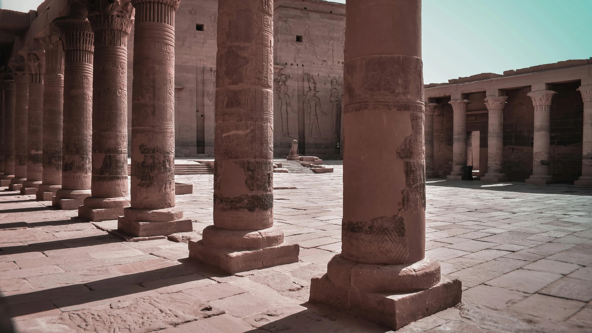 Aswan, Egypt - Majestic columns in an ancient egyptian temple courtyard, aswan, showcasing intricate carvings.
