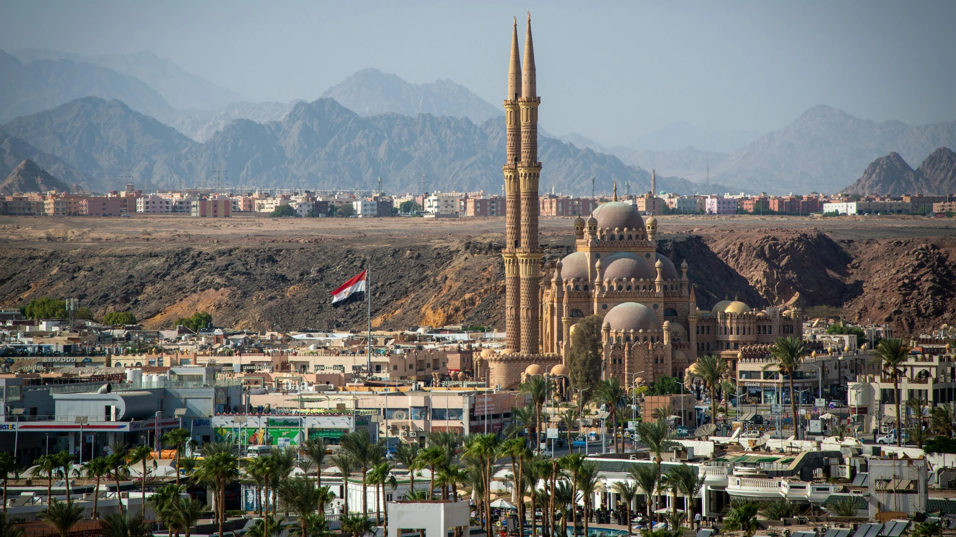 El Alamein, Egypt - Stunning aerial view of al sahaba mosque against sharm el sheikh cityscape and mountains.