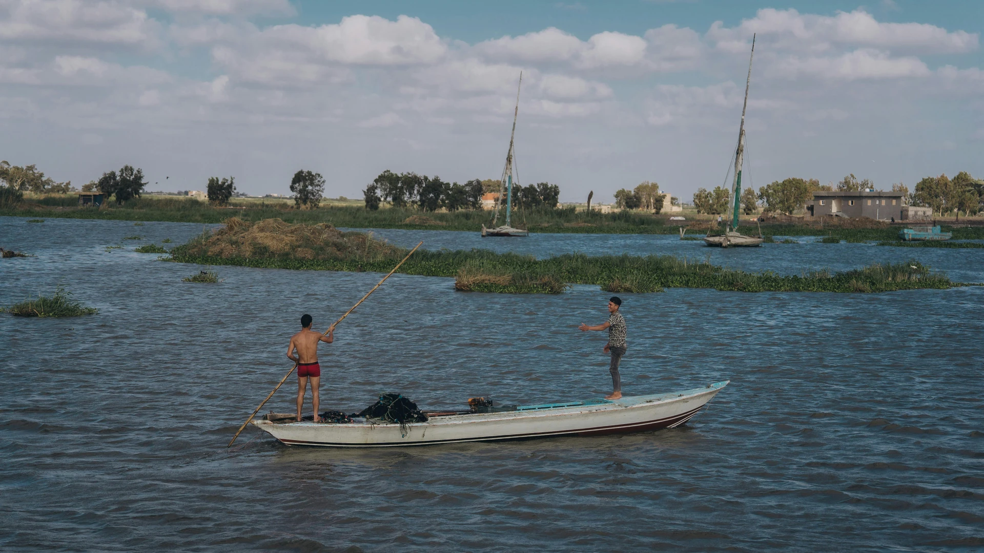 El Alamein, Egypt - Two fishermen engage in traditional fishing on the nile river, capturing authentic egyptian culture.