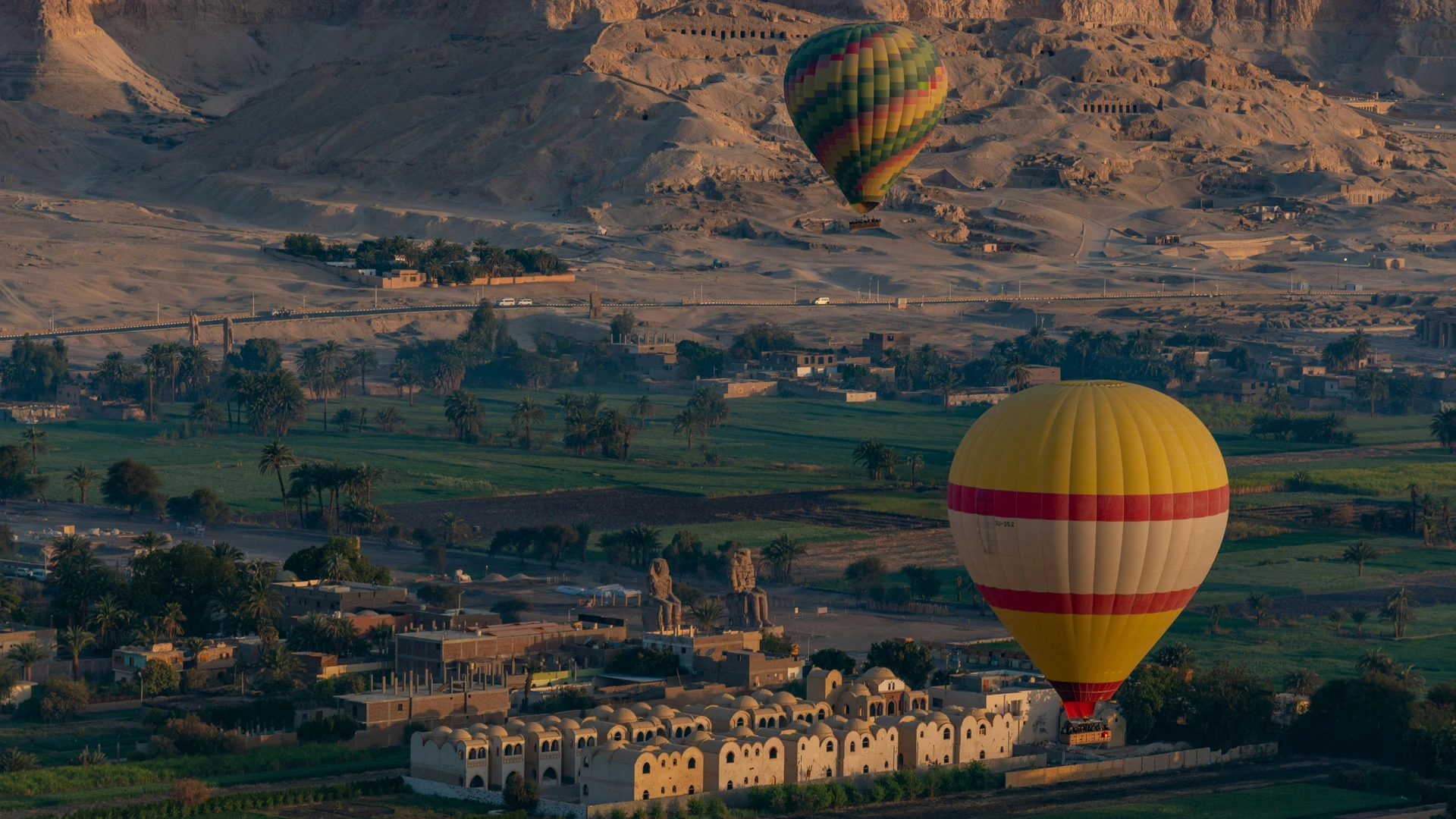 El Alamein, Egypt - Colorful hot air balloons floating over luxor with ancient egyptian landmarks in the background.