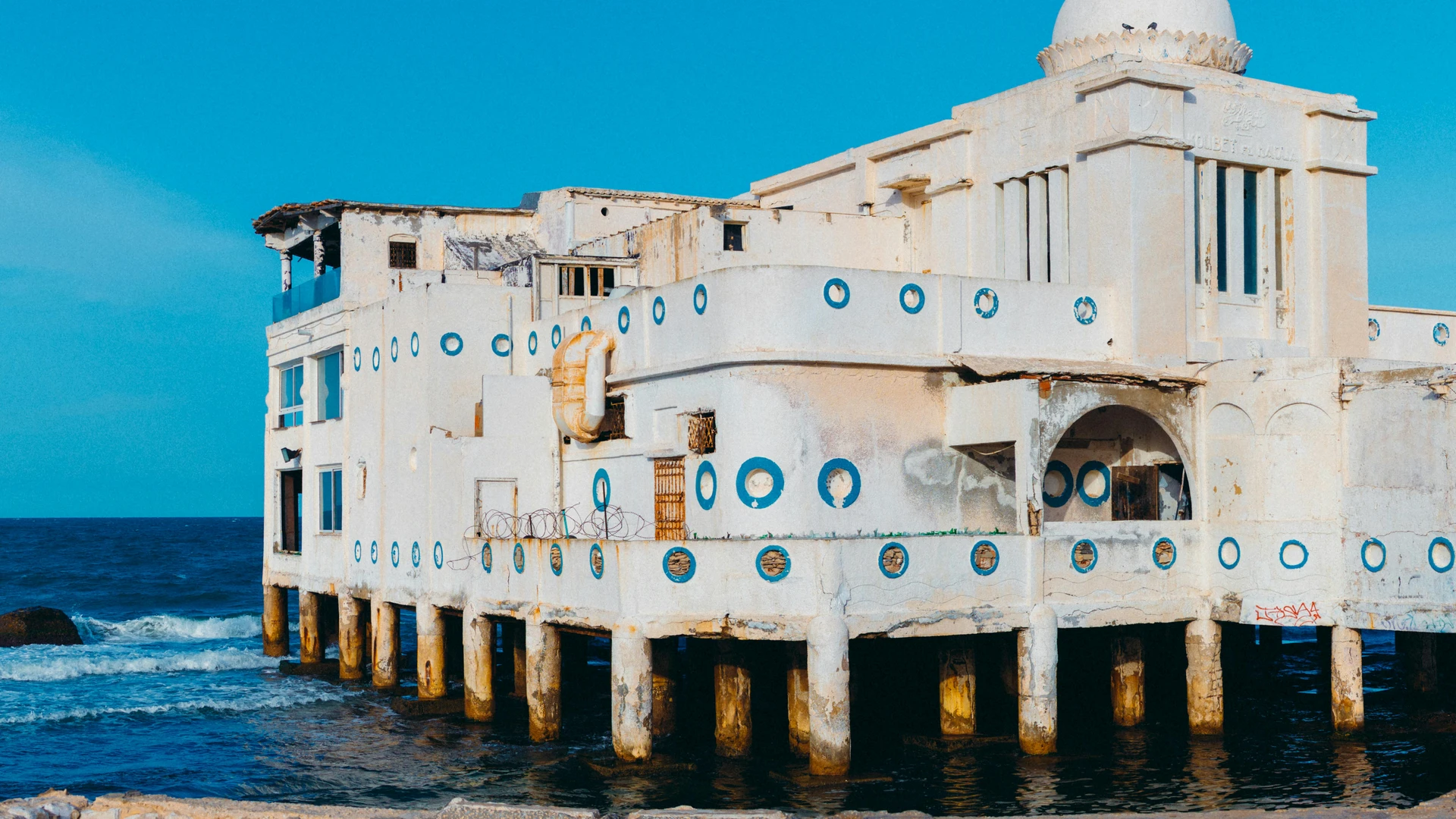 Marsa Alam, Egypt - Striking image of a historic, abandoned building on the coast of la marsa, tunisia, surrounded by the blue sea.
