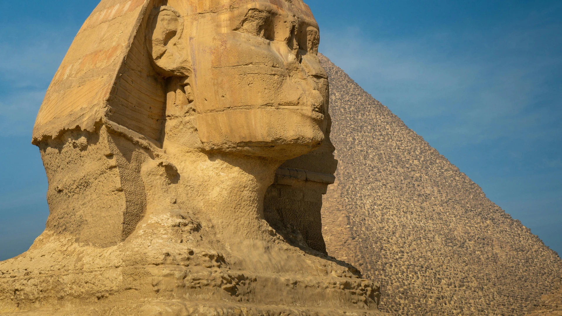 Sahl Hasheesh, Egypt - Iconic view of the great sphinx of giza beside a pyramid under a clear blue sky.