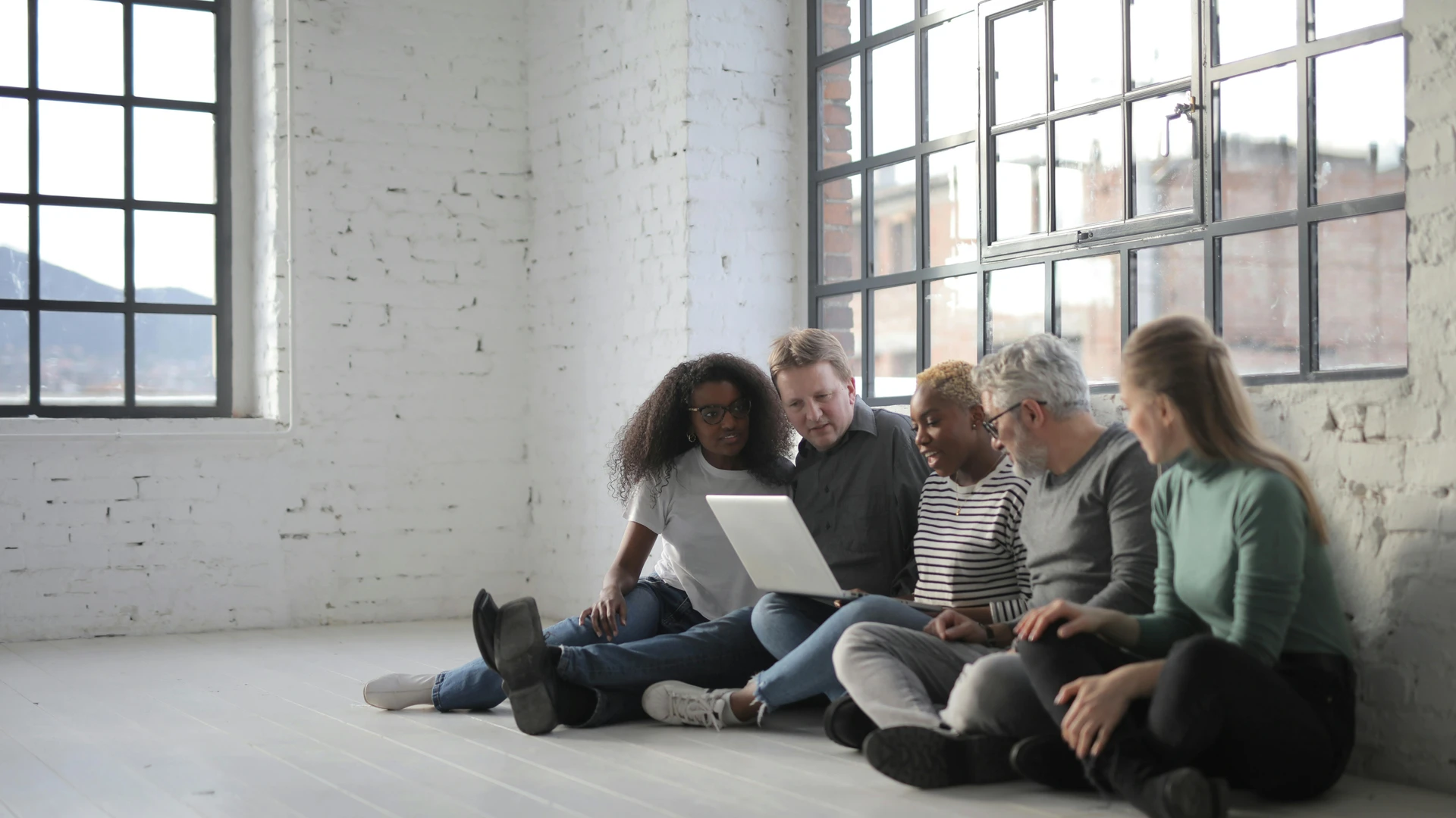 Soma Bay, Egypt - Diverse group of professionals having a casual meeting with a laptop in a bright, modern room.