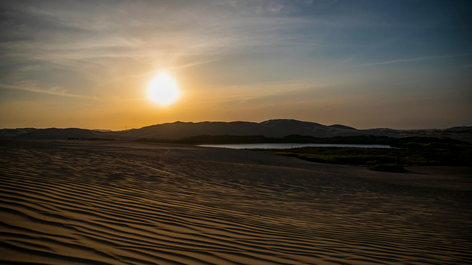 Aswan, Egypt - Captivating sunset over desert dunes in perú, showcasing serene and scenic views.
