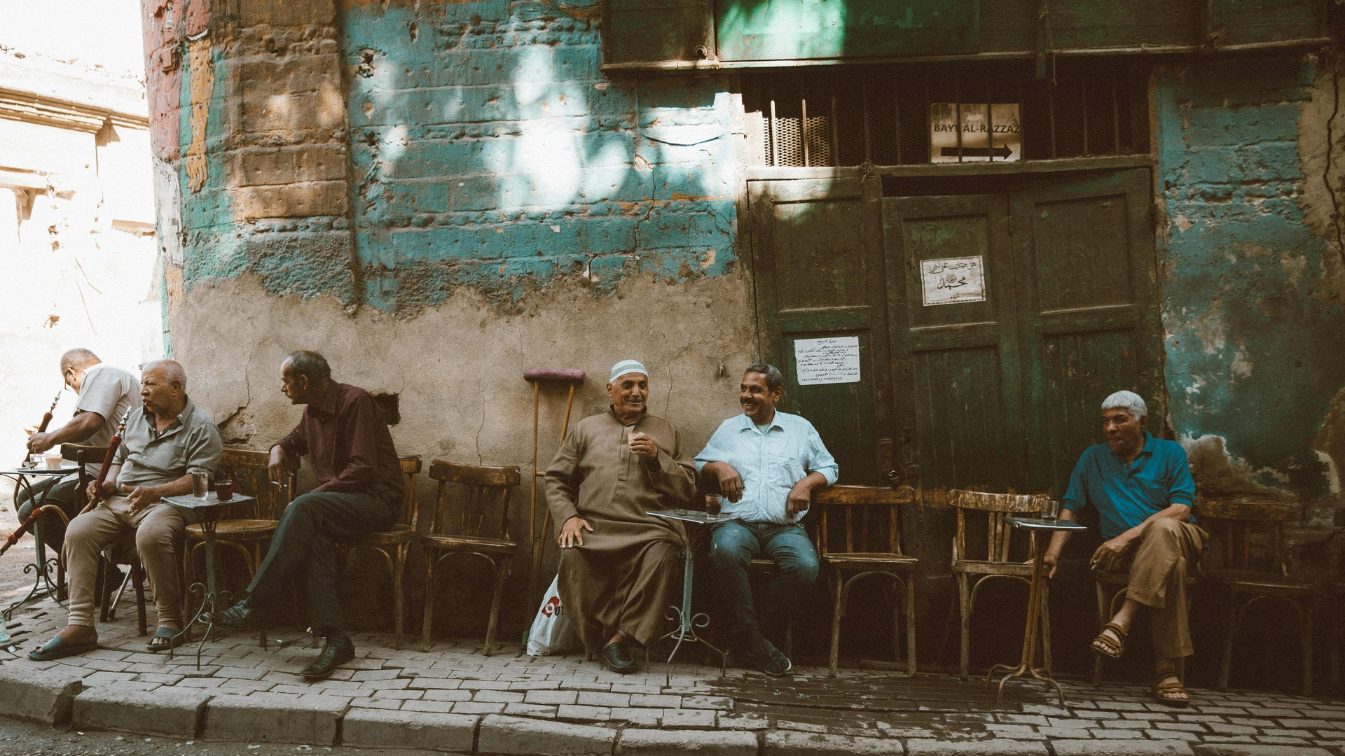 Cairo, Egypt - Local men enjoy a casual gathering outside a café in cairo's historic al-darb al-ahmar district.