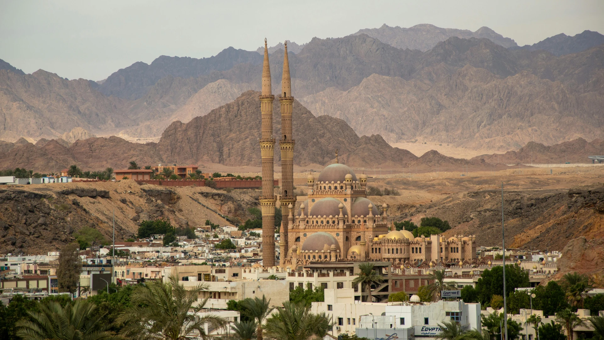 El Gouna, Egypt - Grand mosque with tall minarets in sharm el sheikh set against desert mountains.