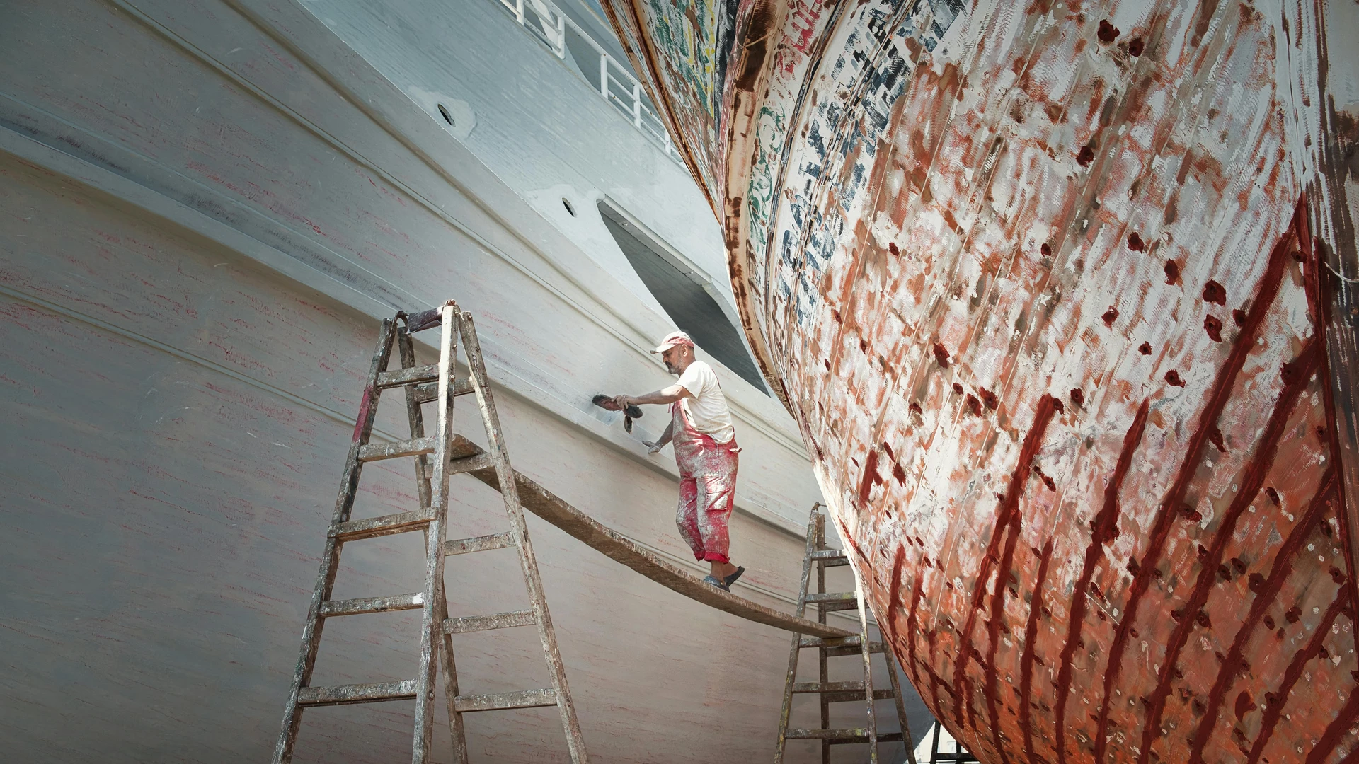El Gouna, Egypt - Worker repairing boats in ras el-bar, egypt. a scene of maritime craftsmanship.