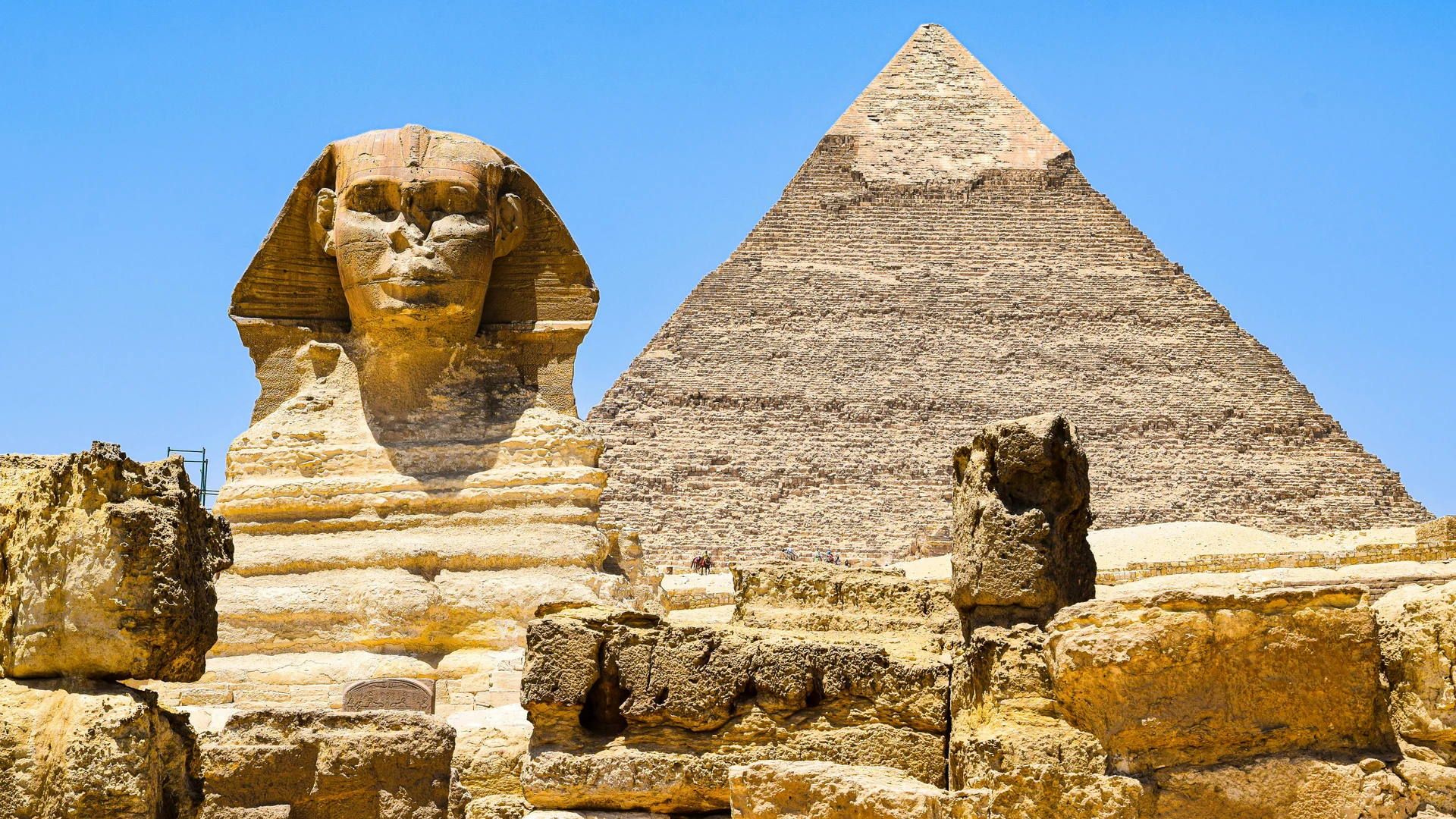 Giza, Egypt - Magnificent view of the great sphinx and pyramid of khafre at giza, egypt under clear blue skies.