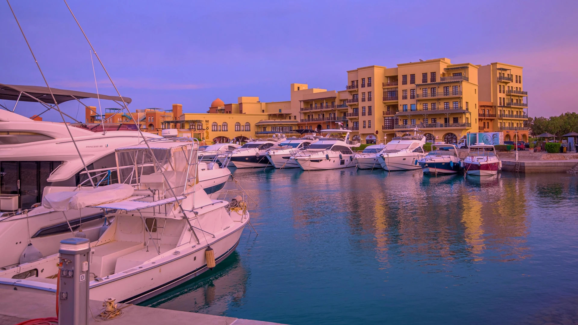 Hurghada, Egypt - Serene view of luxury yachts docked at hurghada marina during sunset, showcasing vibrant architecture.