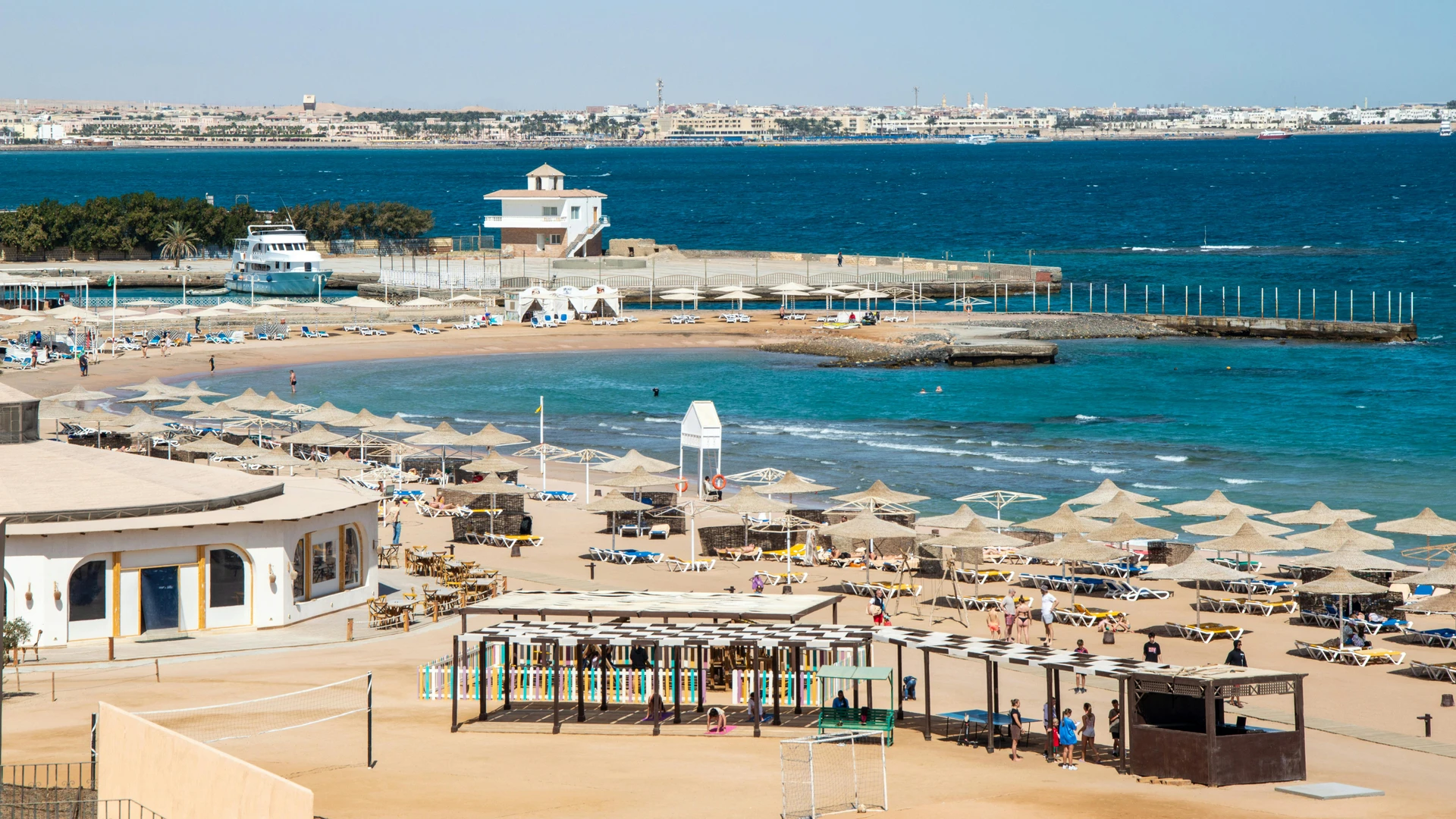Hurghada, Egypt - Aerial view of vibrant beach resort with umbrellas and blue sea.