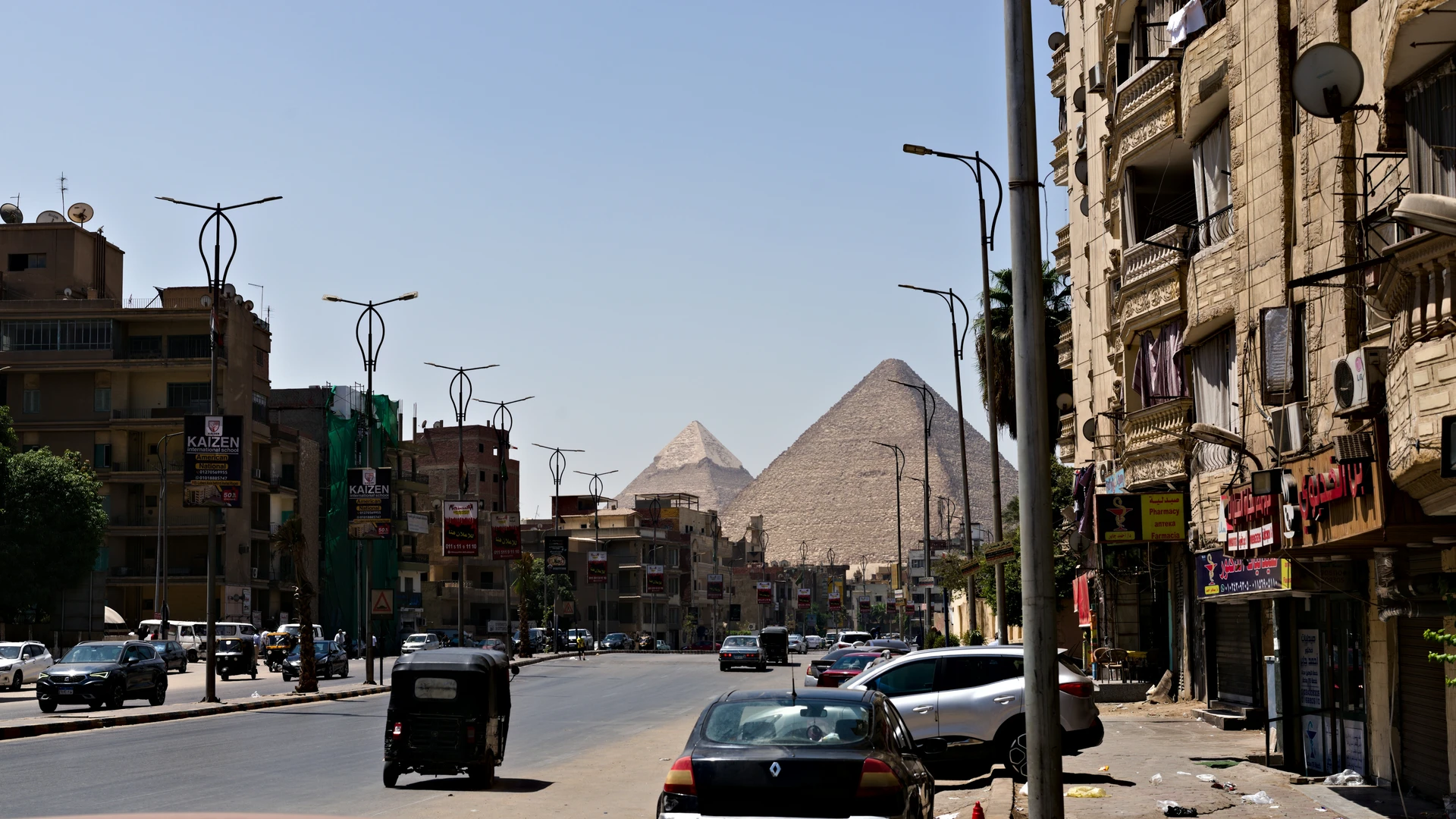 Safaga, Egypt - Pyramids visible over buildings and street traffic