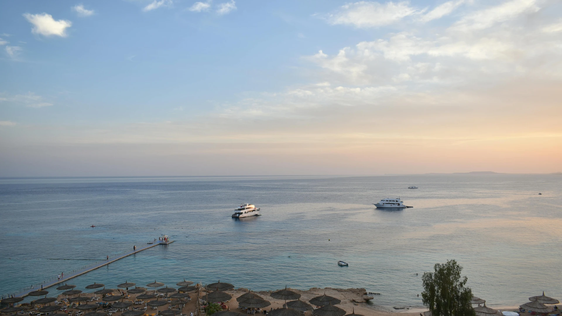 Sharm El Sheikh, Egypt - Stunning aerial view of sharm el sheikh's beach and sea during sunset with boats and parasols.